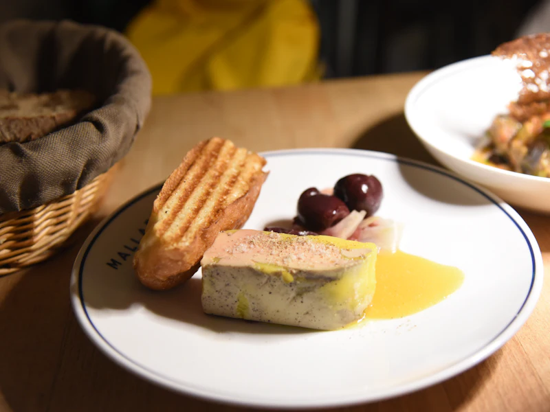 Tranche de foie gras avec des toasts et des olives
