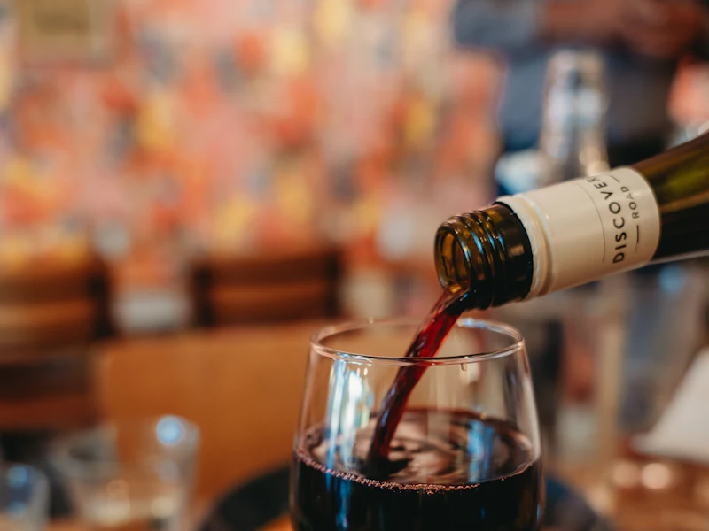 Vin rouge versé dans un verre, sur une table